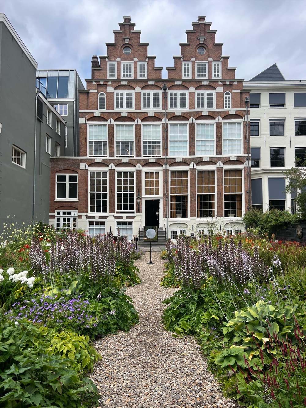 Historic 17th-century Dutch brick mansion with stepped gable facade and flowering wildflower garden in The Hague — AN Art Advisory studio