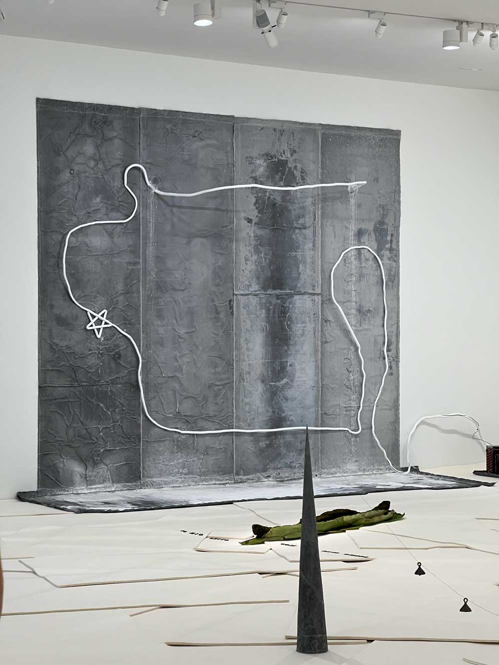 Contemporary installation with a neon line drawing over a large grey textured canvas, with sculptural elements on the floor — art advisory