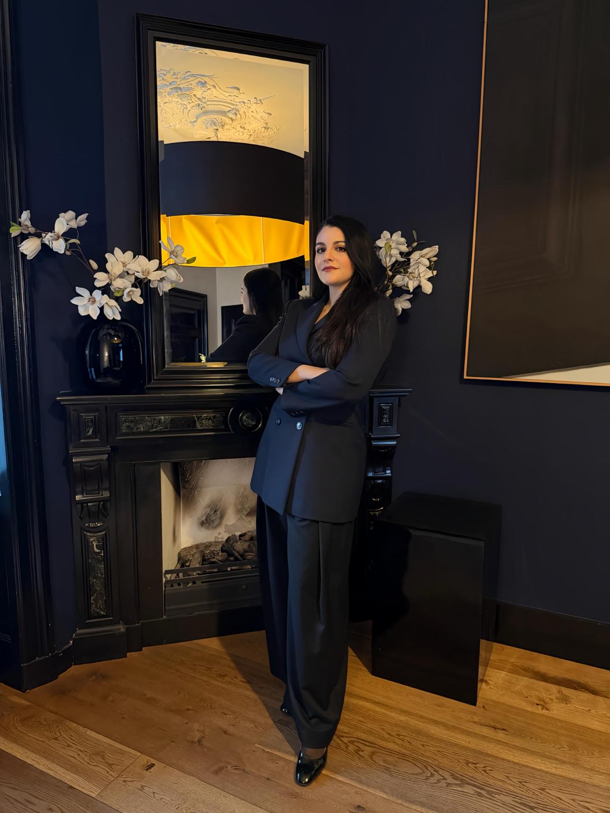 Amalia Nangeroni, art advisor and founder of AN Art Advisory, formal portrait with contemporary artwork and historic fireplace
