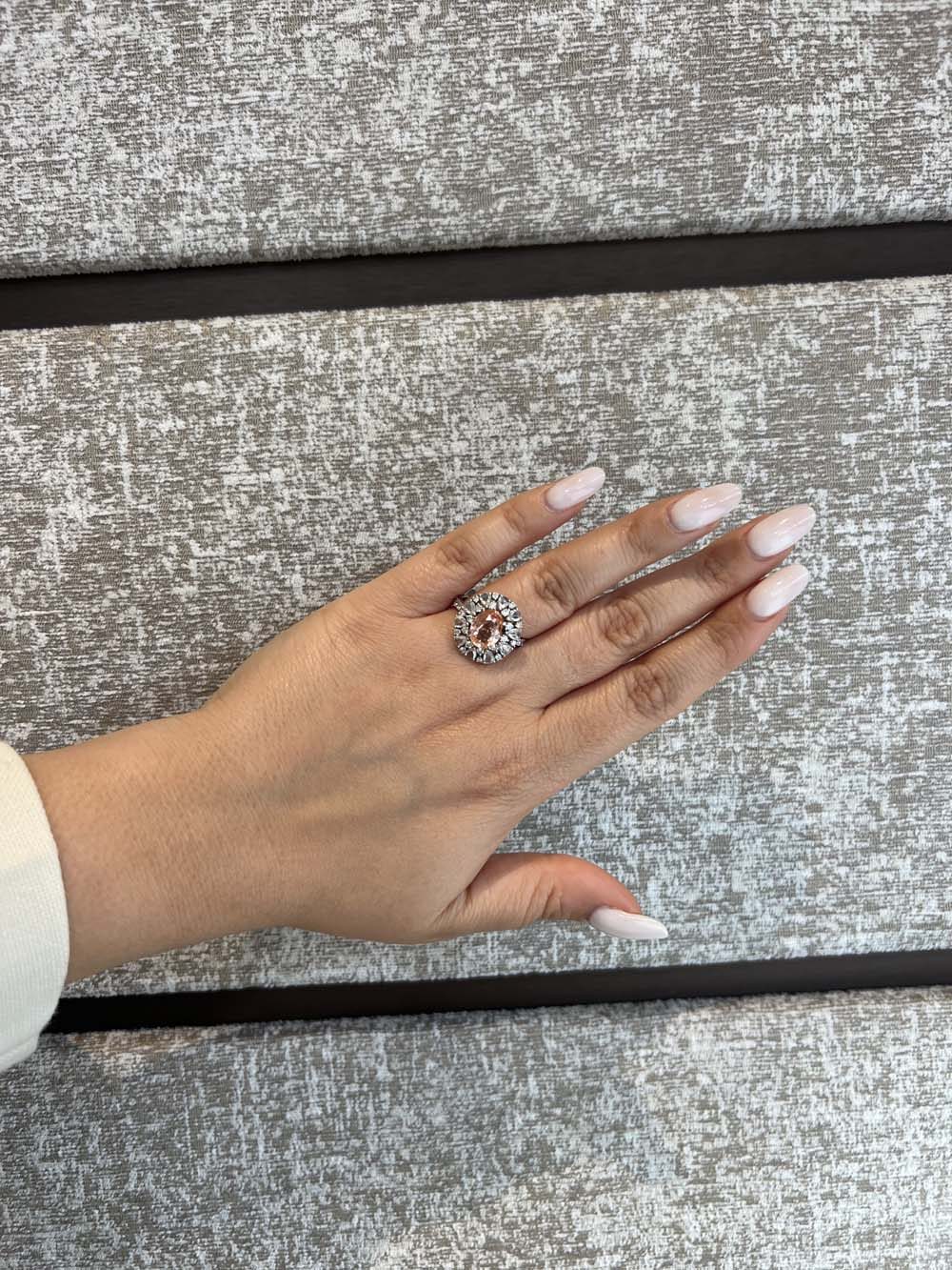 Fancy brownish-orange cushion-cut natural diamond halo ring on hand — rare natural diamond advisory