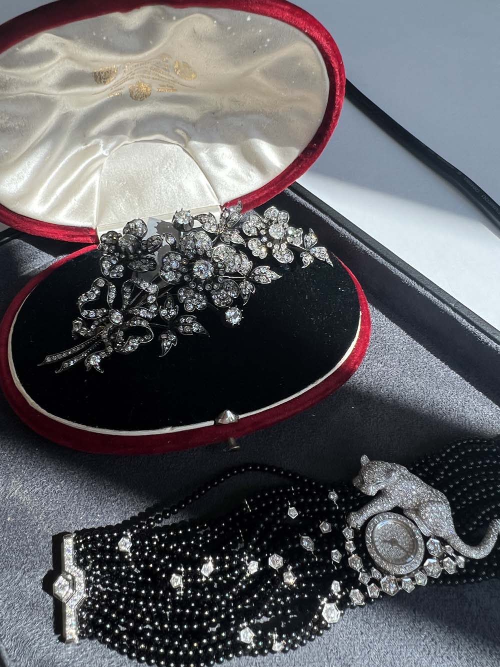 Victorian diamond floral spray brooch in original red leather case with a black seed-pearl bracelet watch — antique jewelry advisory