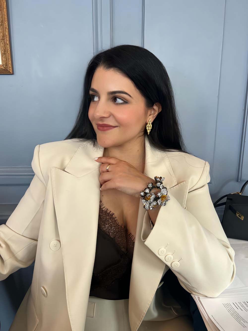 Amalia Nangeroni, founder of AN Art Advisory, in a white blazer displaying a large diamond cuff brooch on her wrist — diamonds and jewelry advisory